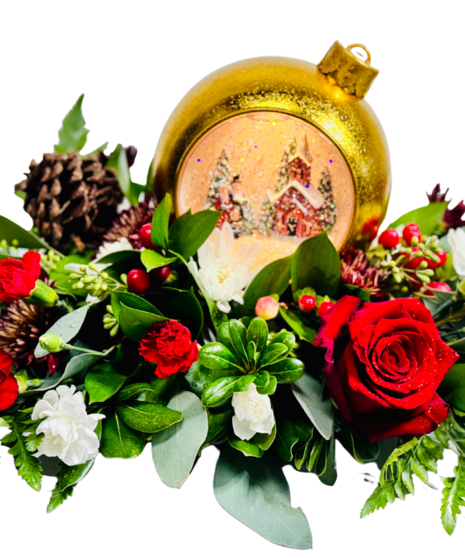 light up holiday snow globe surrounded by fresh holiday flowers