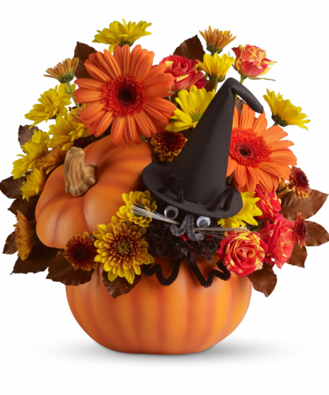pumpkin vase filled with fall-toned orange and yellow flowers accented with black cat